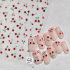 Nail art with cherry designs on a light background