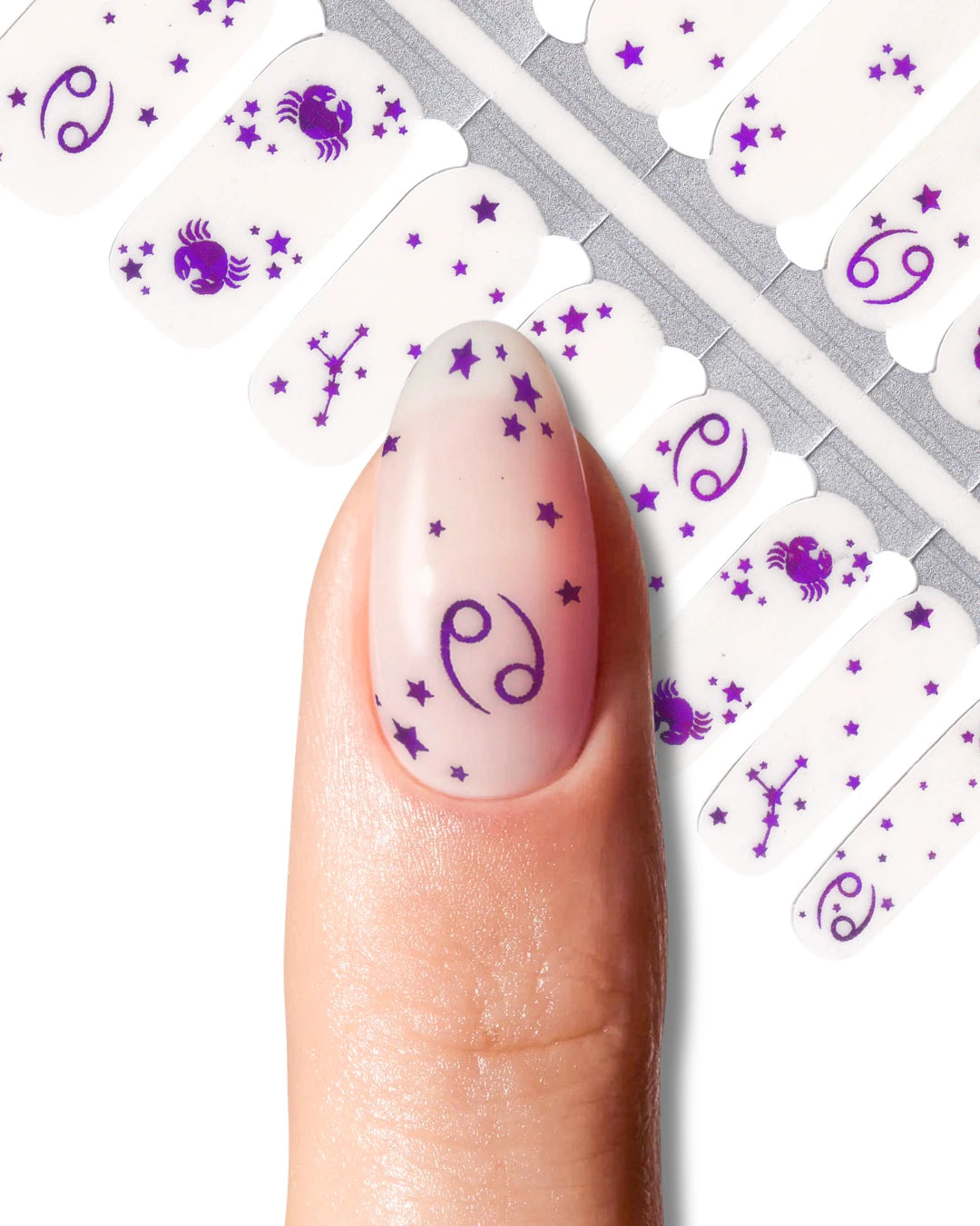 Nail wrap with purple zodiac symbols and star patterns.