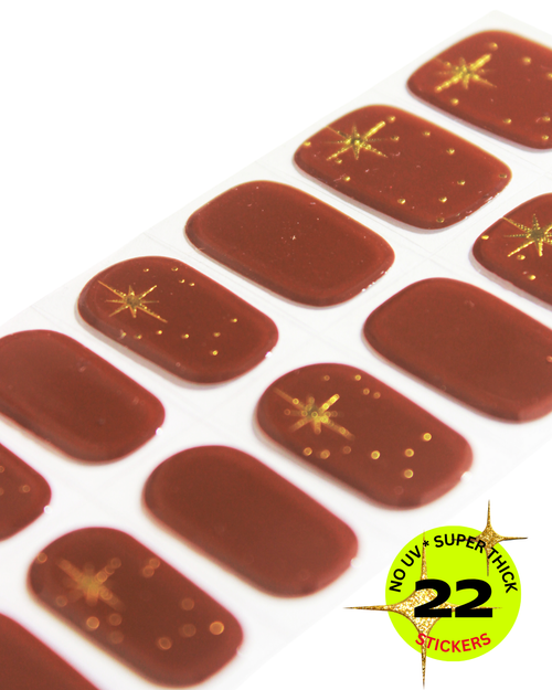 Rust brown nail wrap stickers with gold star accents.