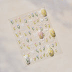 Sheet of decorative nail art stickers with flowers and butterflies on a beige background