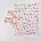 Nail art with cherry designs on a textured white background