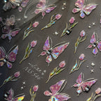 Iridescent butterfly and flower stickers on a dark background 