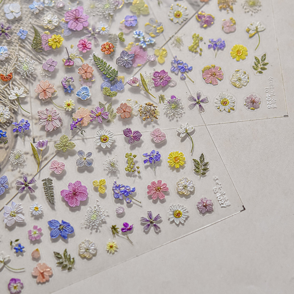 Collection of colorful floral stickers on a clear sheet with a light background