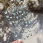 Sheet of butterfly stickers held by a hand with a blurred natural background