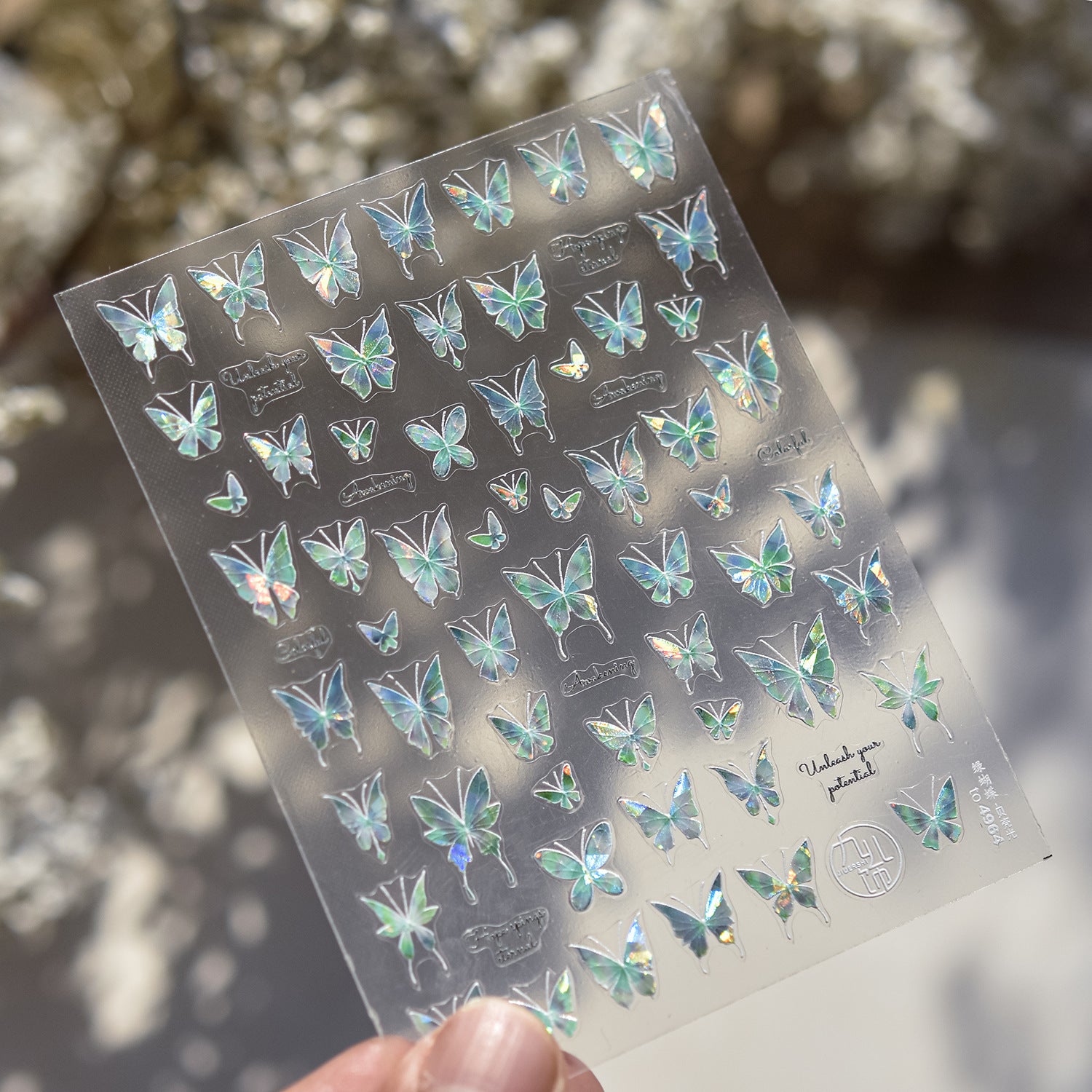Sheet of butterfly stickers held by a hand with a blurred natural background