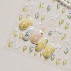 Nail art with floral designs on a beige background with floral patterns