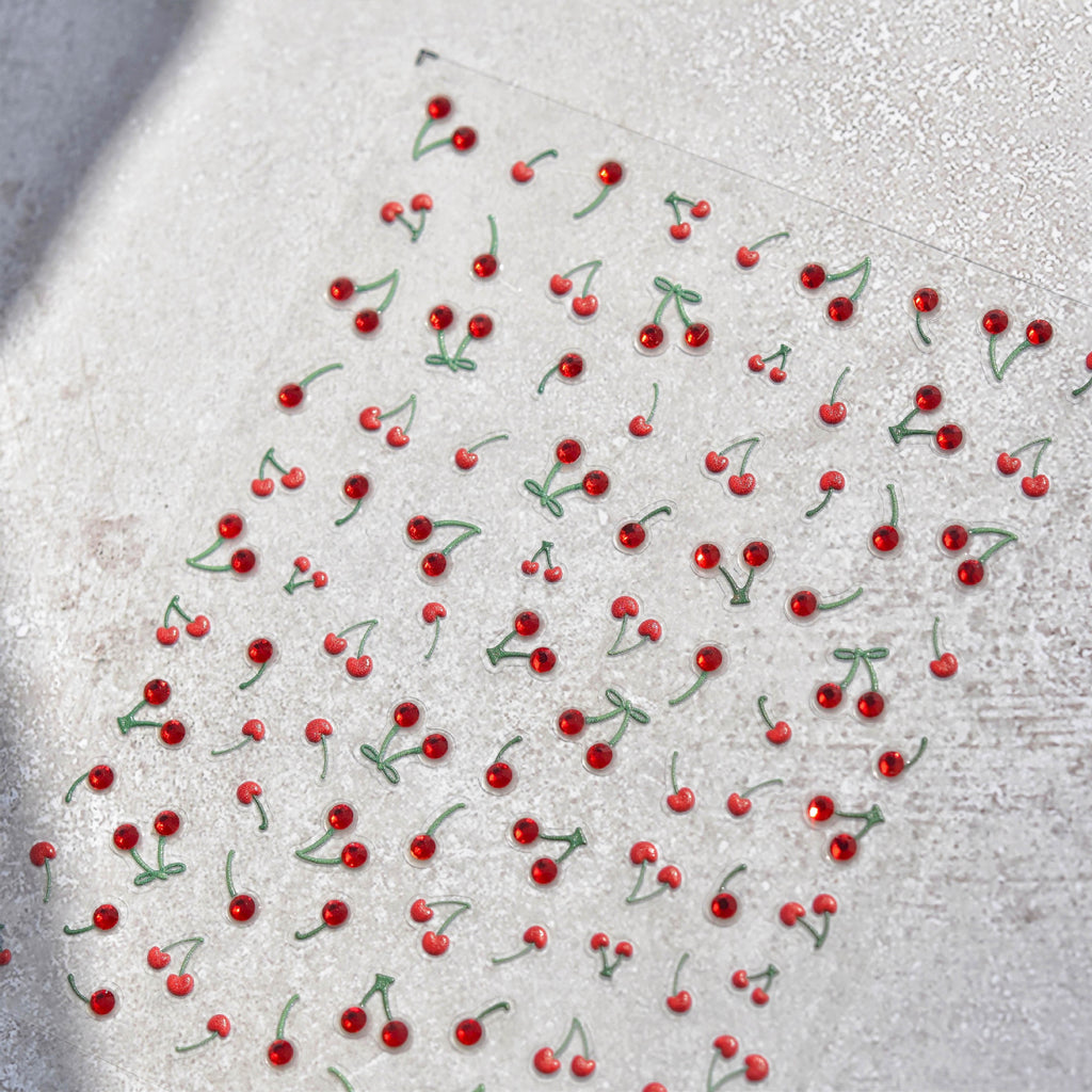 Red berries with green stems on a textured white surface