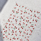 Red berries with green stems on a textured white surface