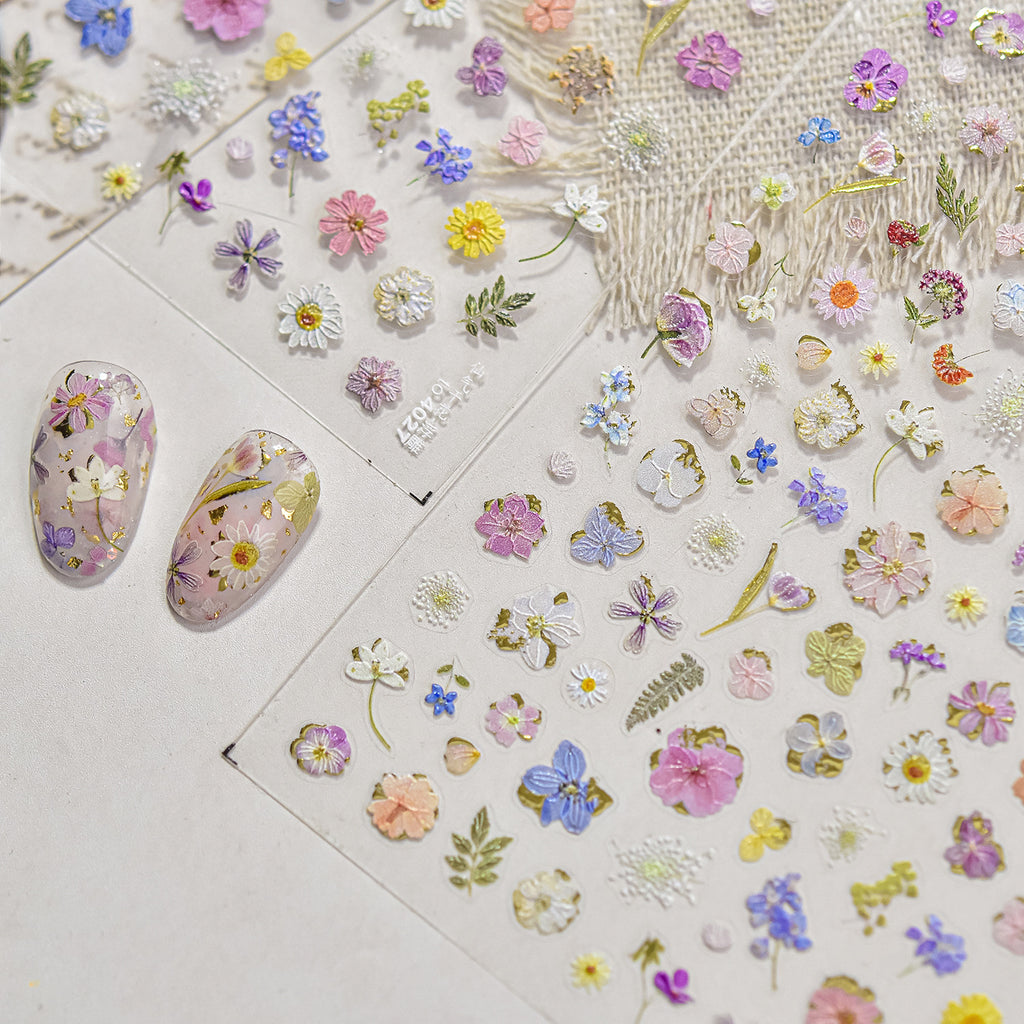 Floral nail art stickers on a white surface with nail samples.
