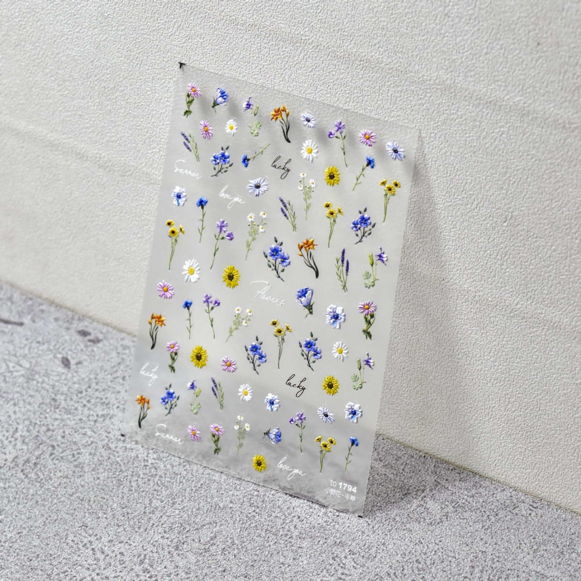 Sheet of small floral stickers on a textured surface