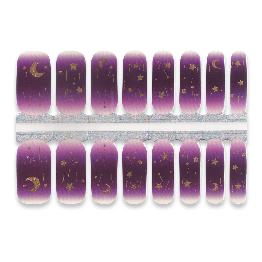 Purple nail wraps with gold moon and star designs on a white background