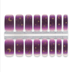 Purple nail wraps with gold moon and star designs on a white background