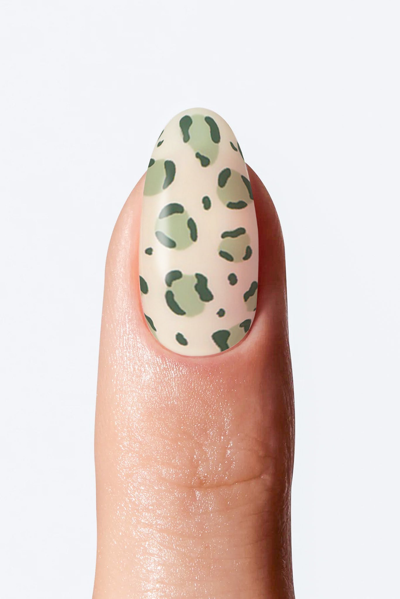 Nail with a green and beige spotted design on a white background
