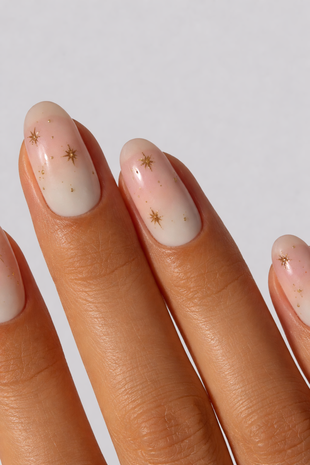 Nail art with gold star designs on a light background