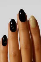 Hand with black and gold nail wrap on a plain background