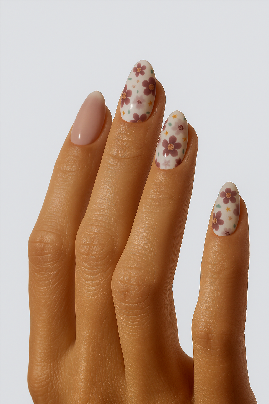 Hand with floral nail design on a plain background