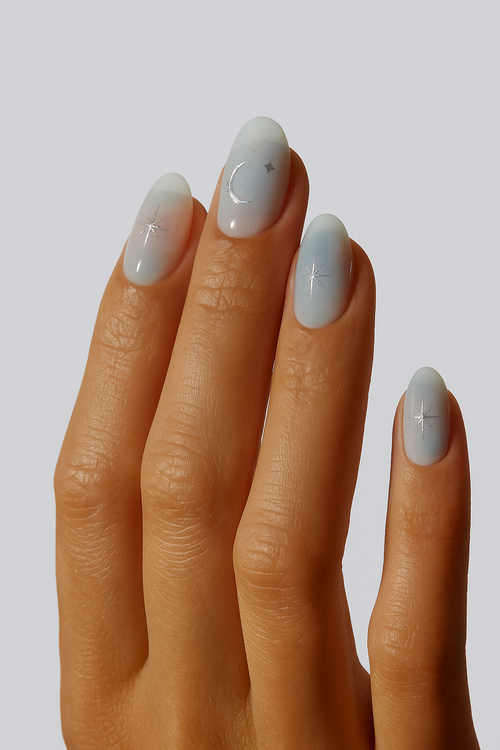 “Cool grey blue nail wraps with silver star and moon accents on hand”