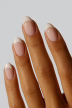 “Close-up of hand with nude French tip nail wraps”