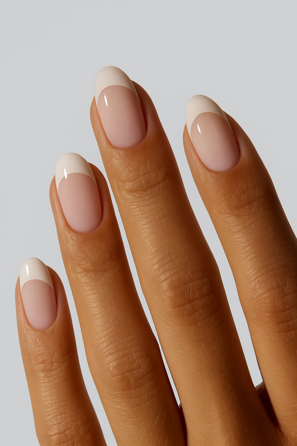 “Close-up of hand with nude French tip nail wraps”