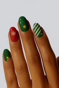 Christmas-themed nail wraps with red, green, star and snowflake manicure”