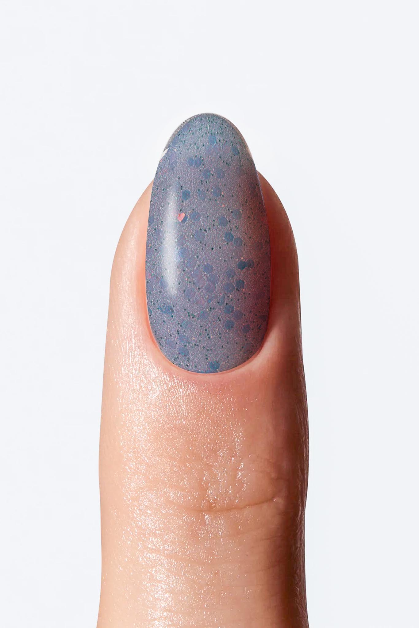 Soft blue speckled glitter nail wrap with subtle sparkle applied on a single finger.