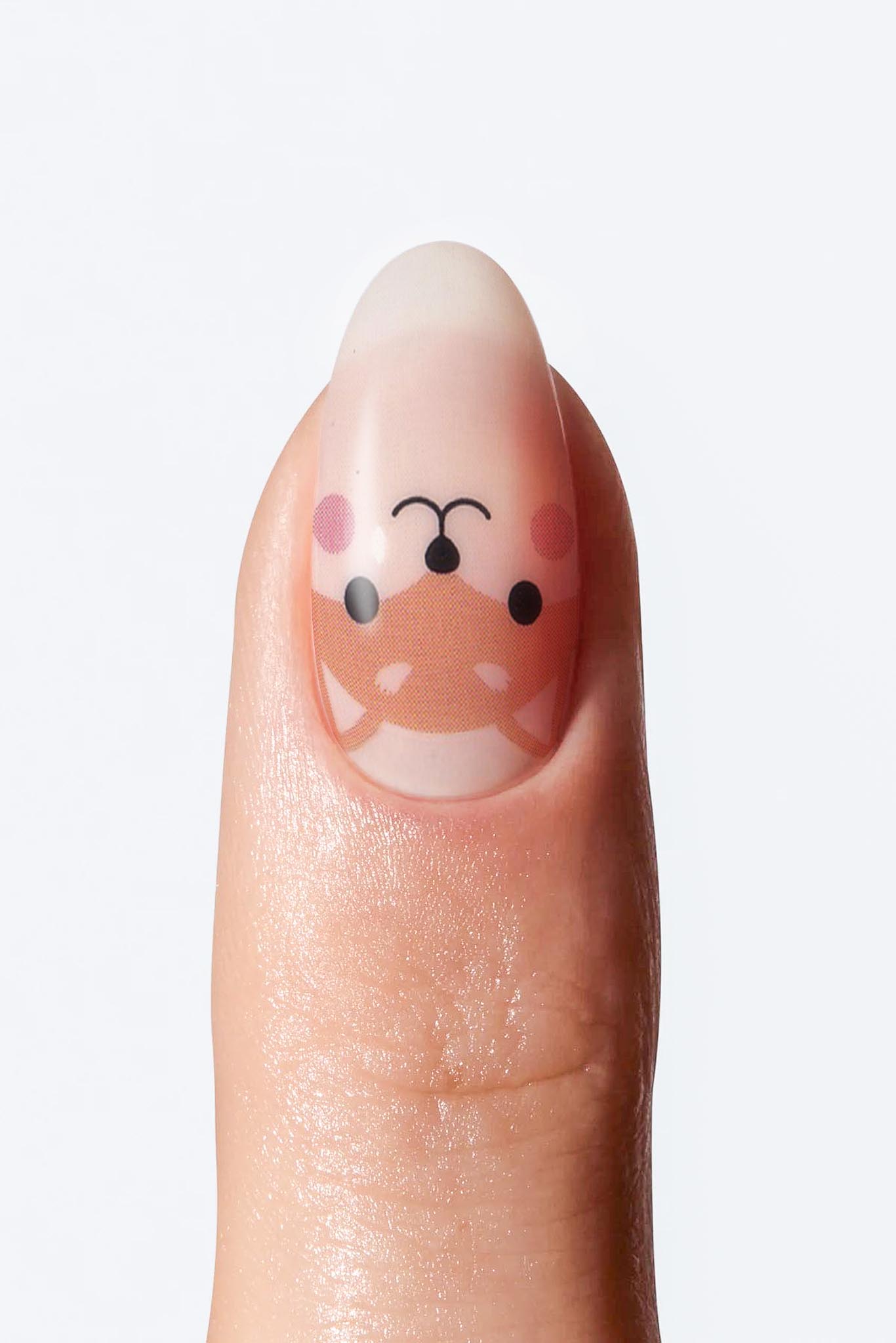 Adorable fox-themed nail wrap featuring playful fox illustrations, on single nail.