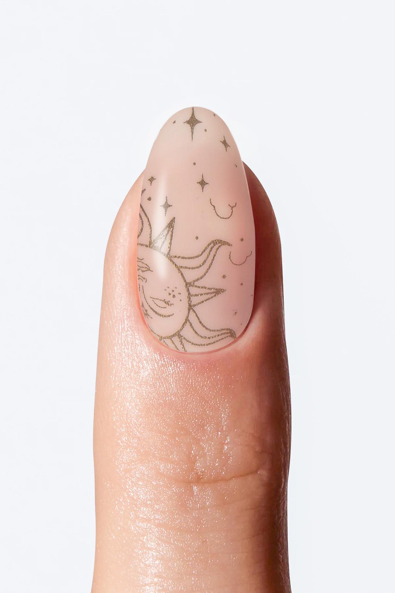Sheer nude nail wrap manicure with delicate sun and star art.