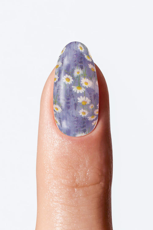 Nail with purple floral design on a light gray background
