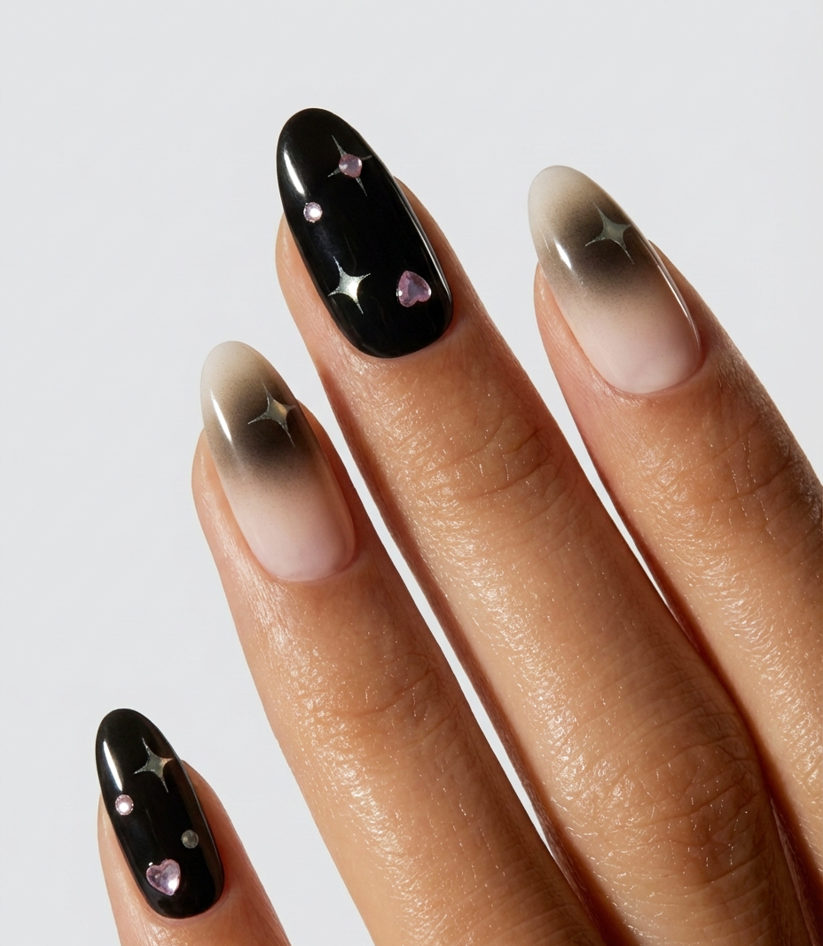 Nail art with black, gold, and pink design on a neutral background