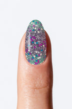 Nail with multicolored speckled design on a light  background