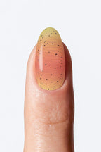 “Peach and yellow gradient nail wrap with black speckle pattern”