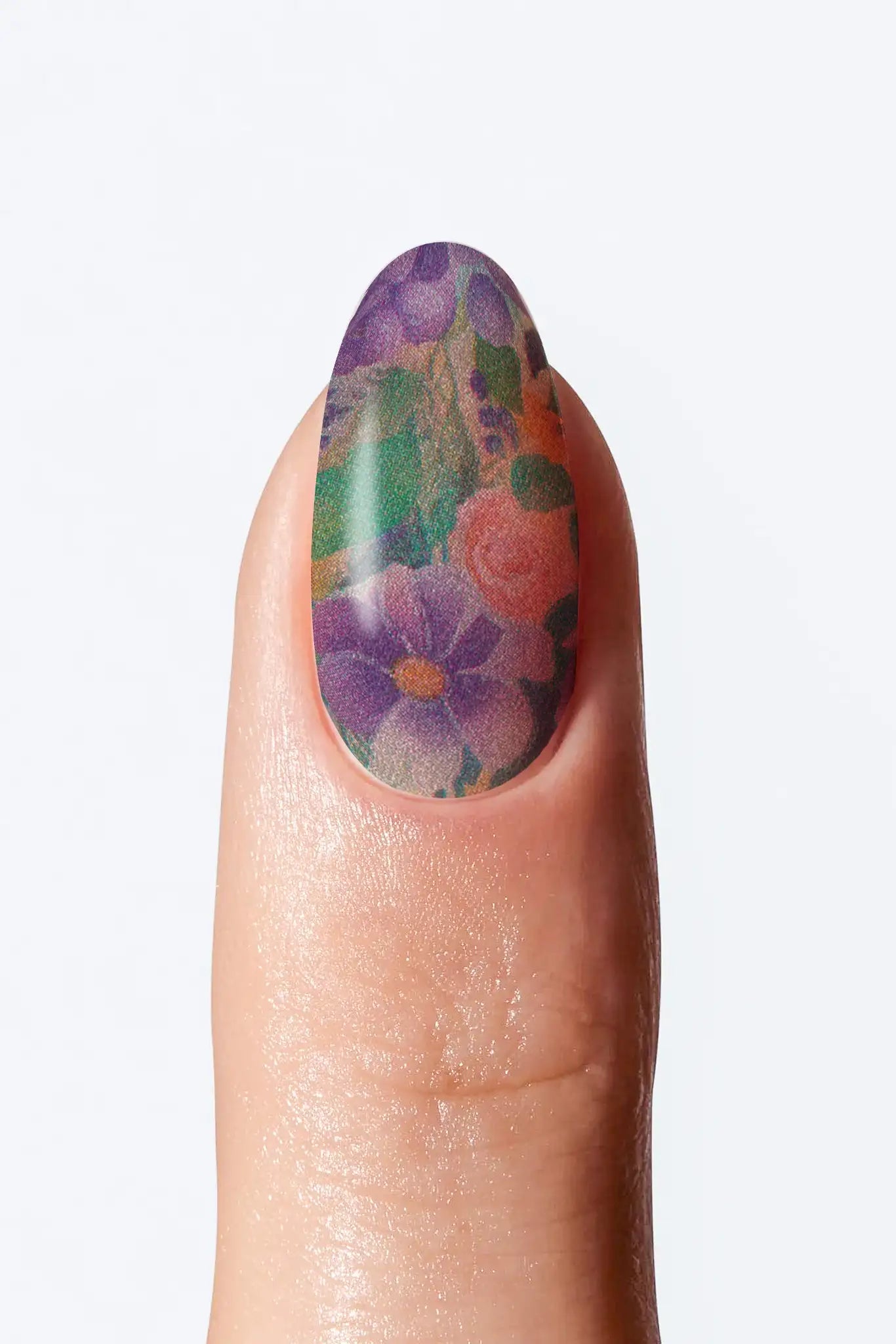 A close-up image of a fingernail with a floral nail art design nail wrap .