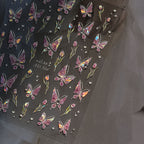 Sheet of butterfly and flower stickers with rhinestones on a dark background