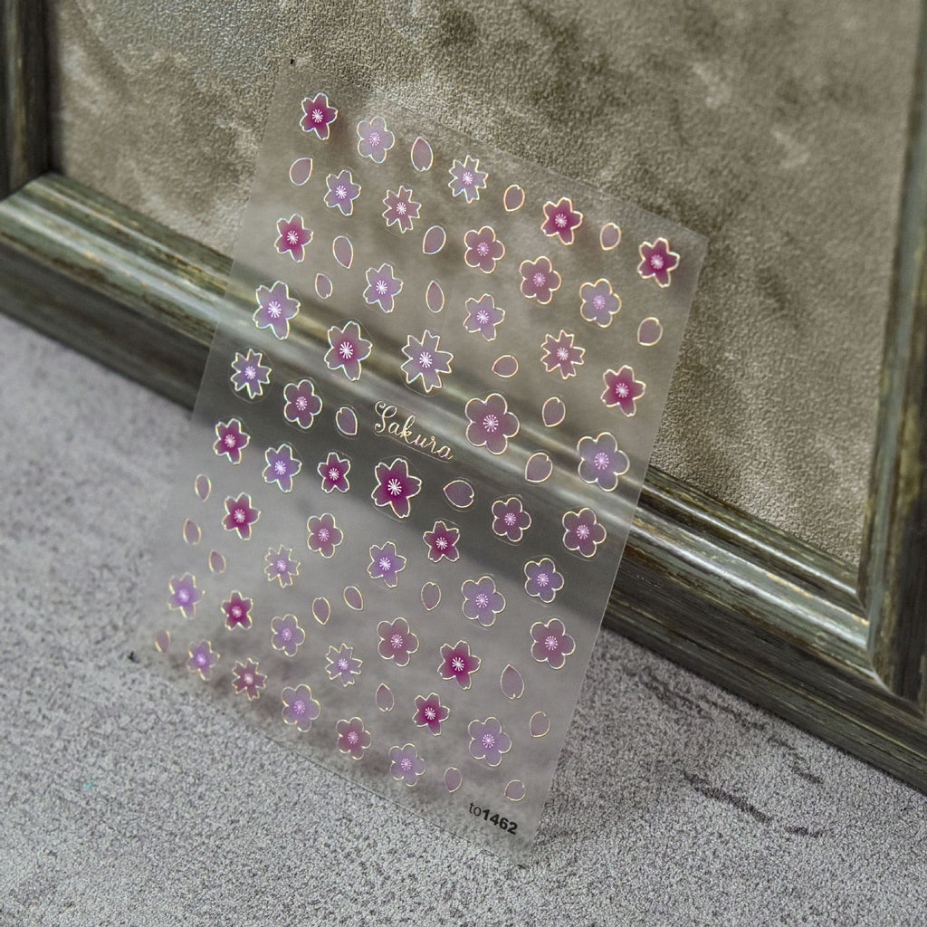 Transparent sheet of pink and purple sakura flower nail art stickers with gold outline.