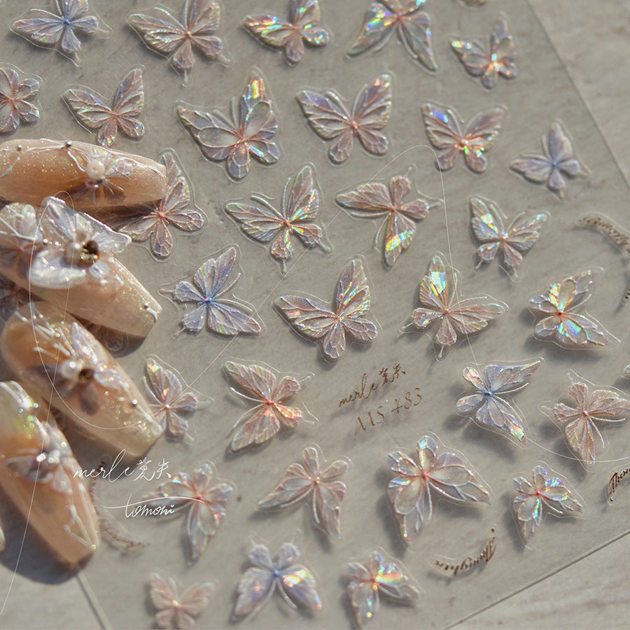 A variety of nail art stickers with butterfly wing designs, featuring glitter and transparent finishes, displayed on a flat surface.