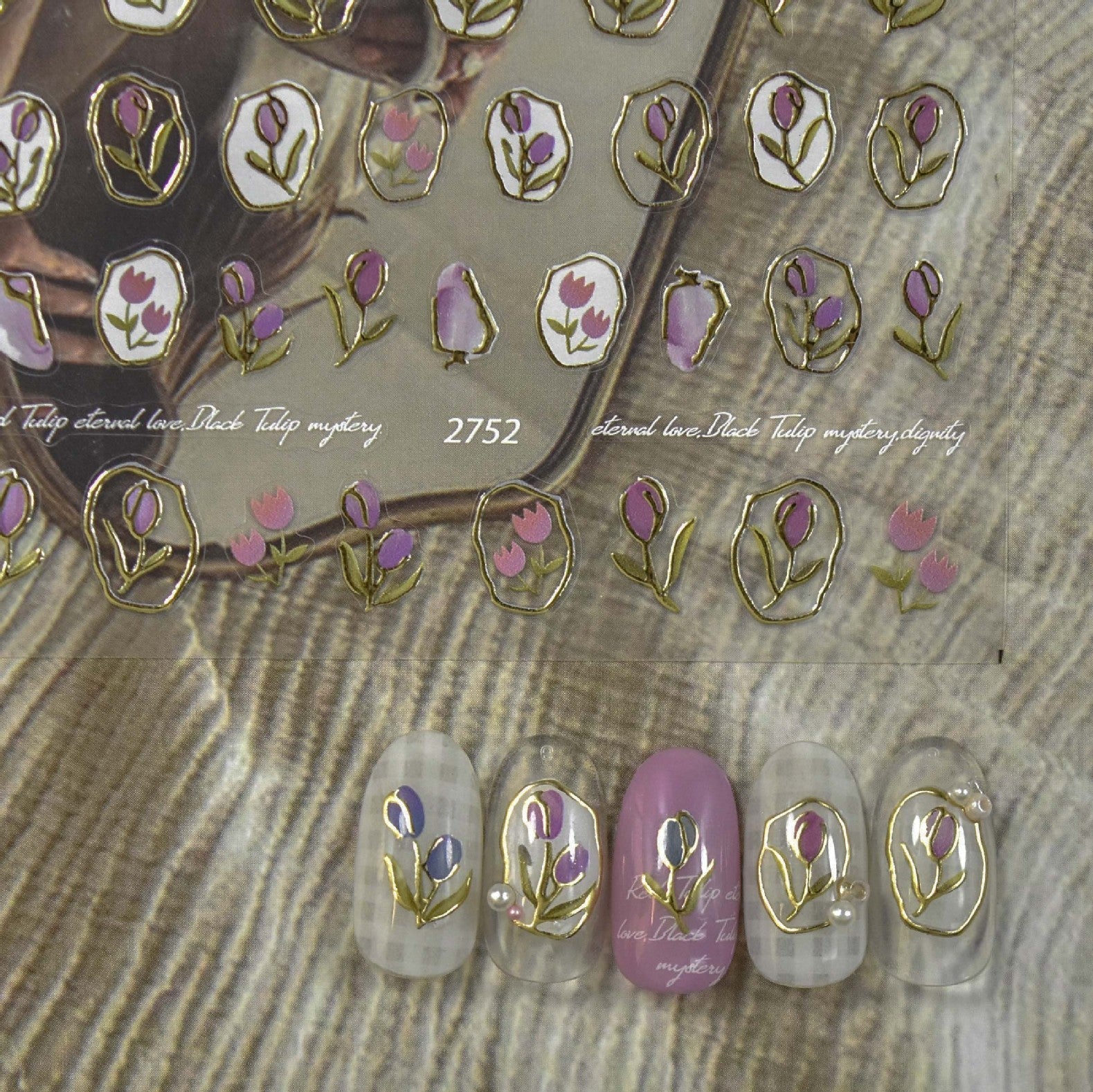 Floral nail art sticker sheet with tulip designs outlined in gold, shown with decorated sample nails.