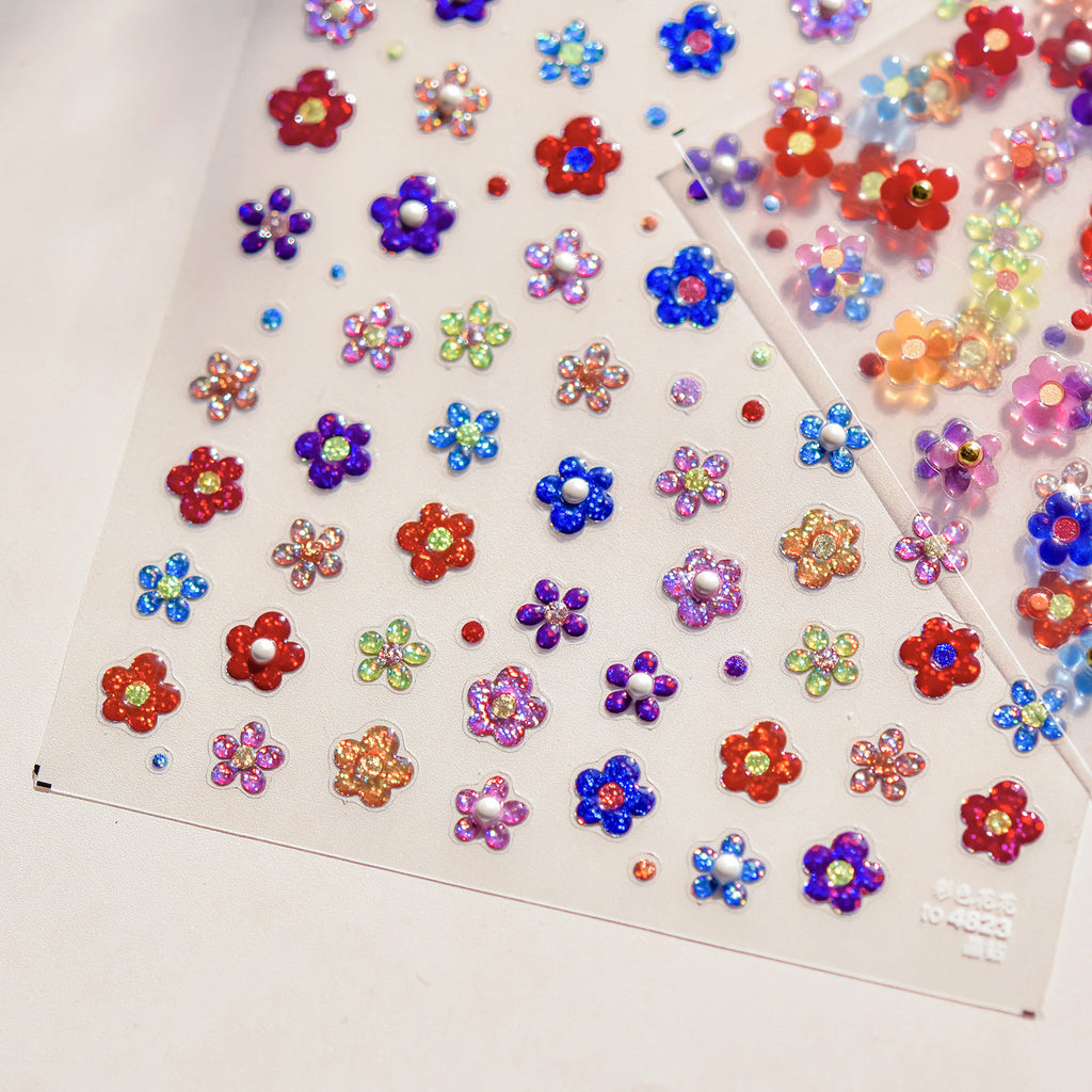 A sheet of nail stickers featuring various colorful glitter flowers designed.