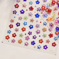 A sheet of nail stickers featuring various colorful glitter flowers designed.