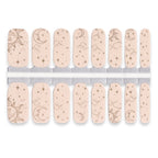 Celestial nude nail wraps featuring sun, moon and star illustrations on soft beige base.